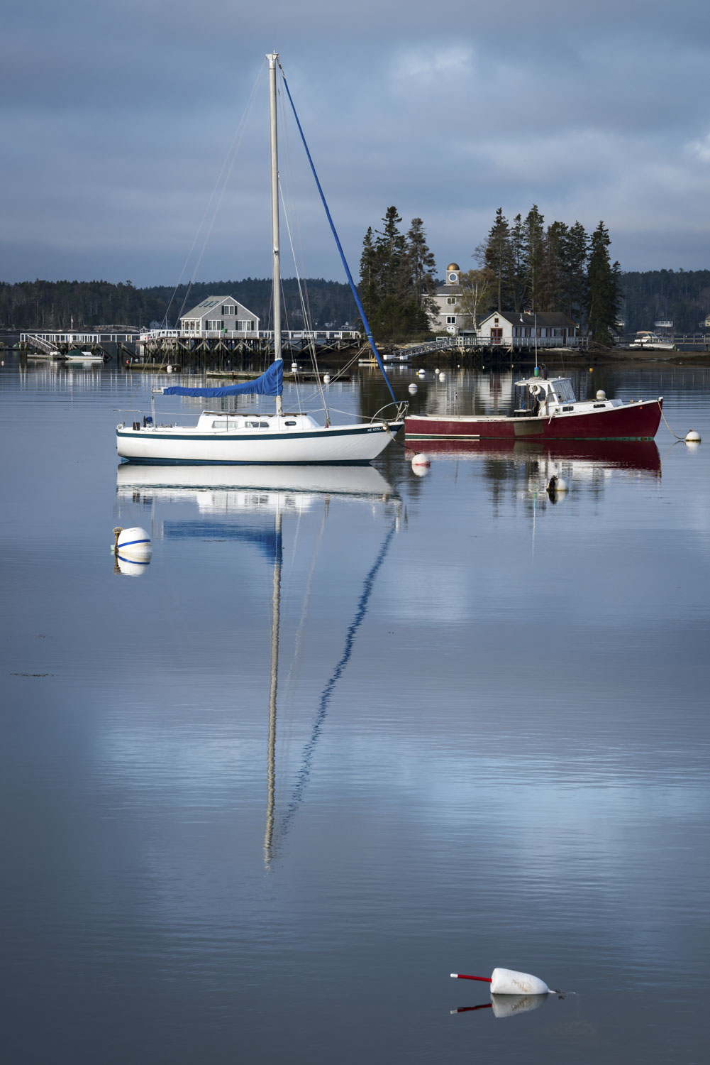 A white and a red ship reflected in the water