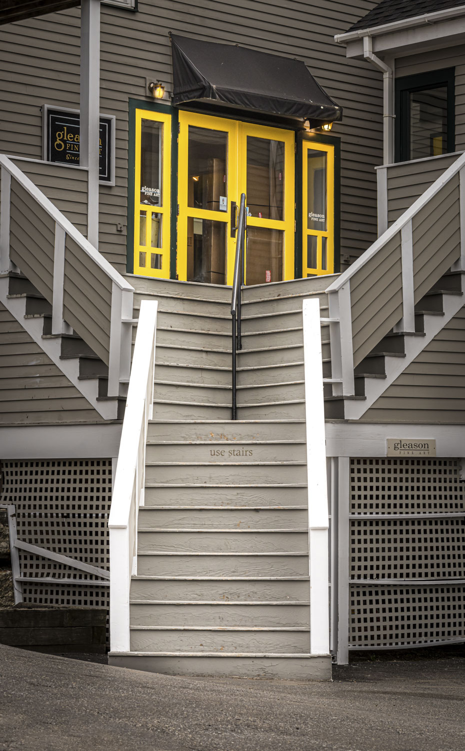 Y-shaped stairs leading to a yellow door