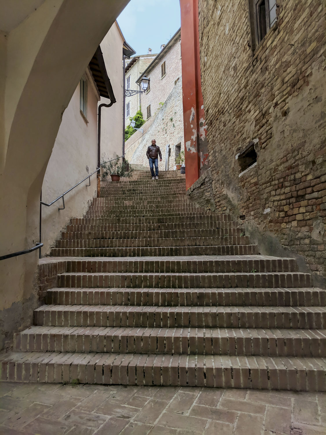 A broad stairway with a man walking down them. 