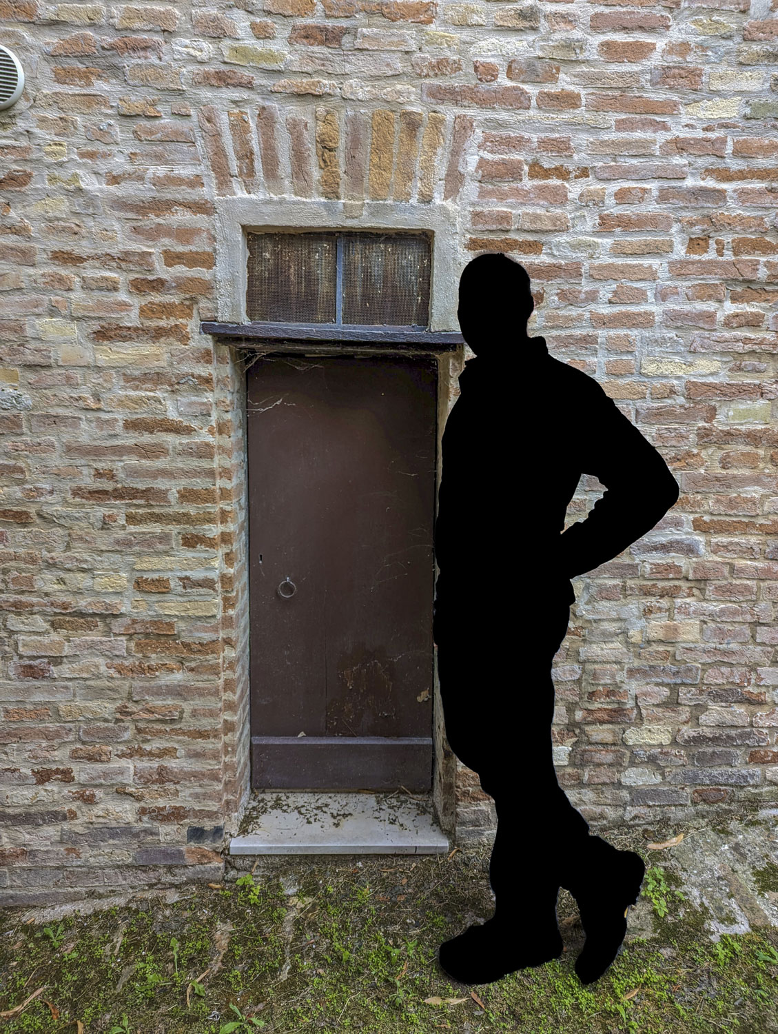 A very small door with the sillhouette of a man in Italy