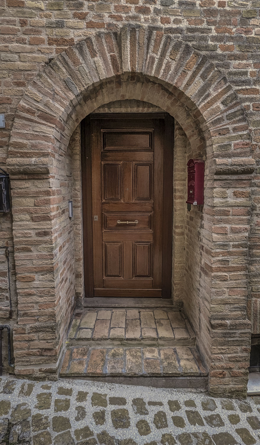 A door in Italy with a red fire alarm box near it