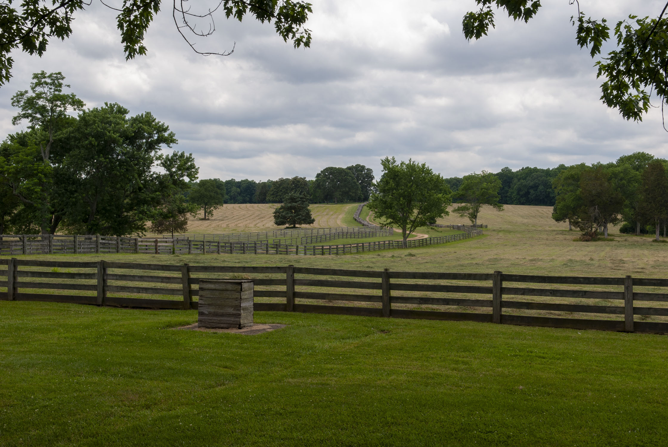 hayed fields with wooden fences along a dirt road