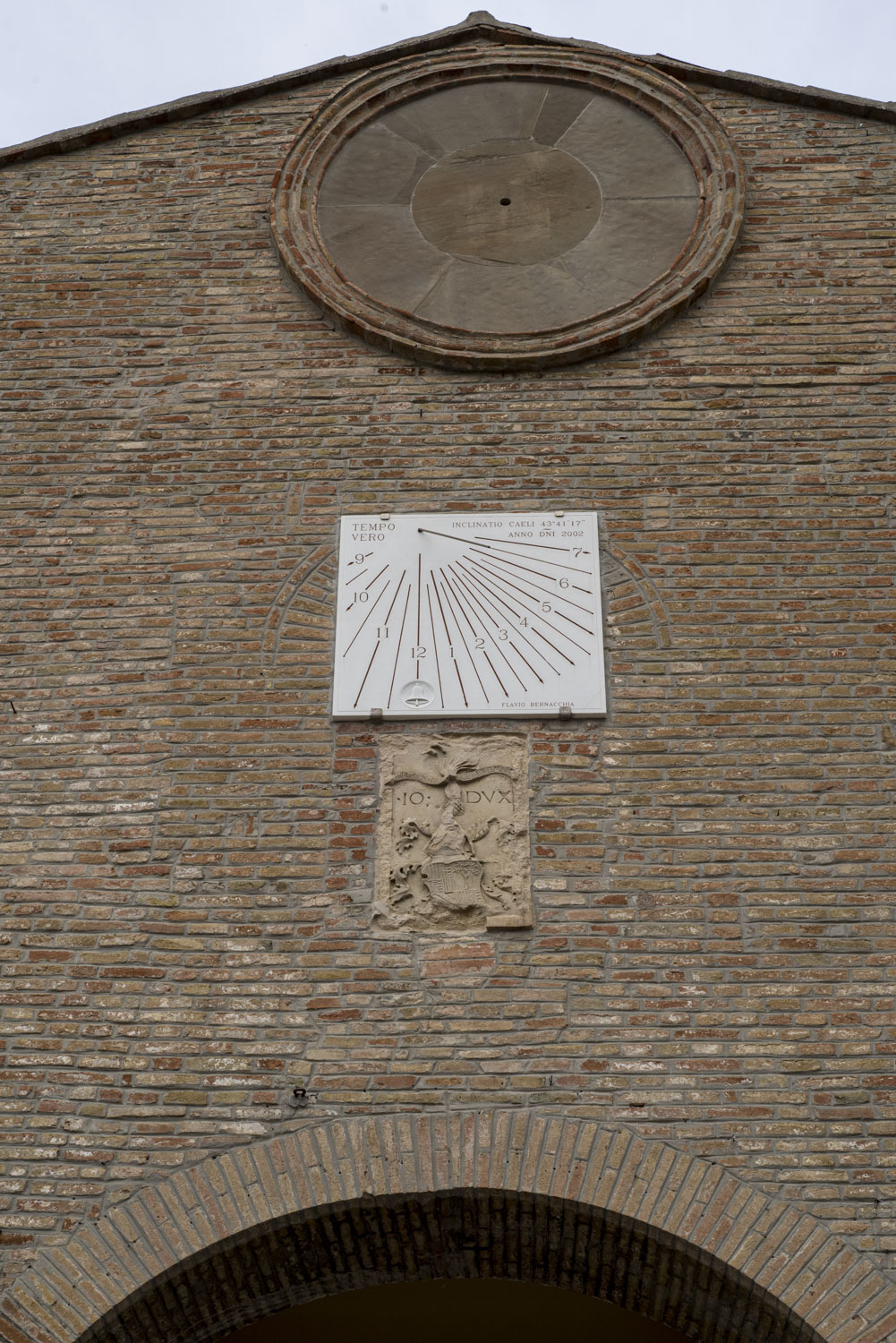A sundial on a wall, with an empty spot above it for an analog clock.