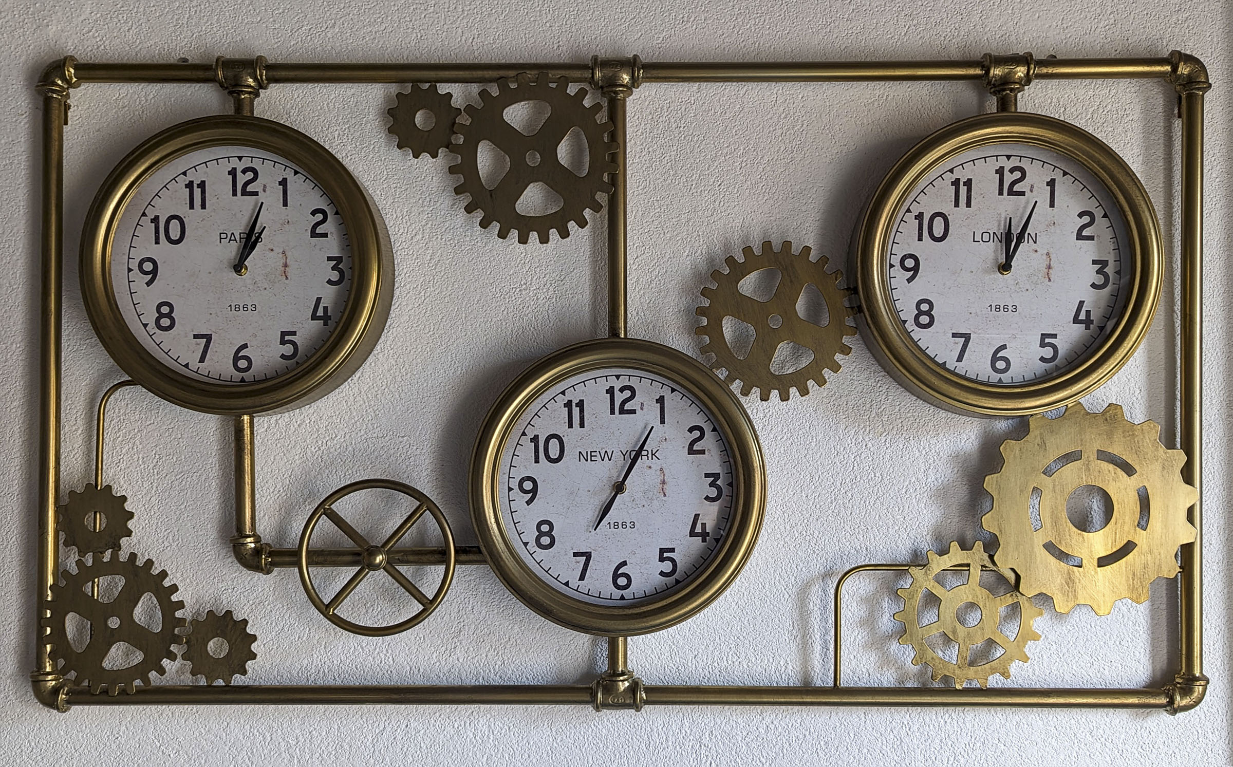 A wall clock with three displays that represent 3 time zones.