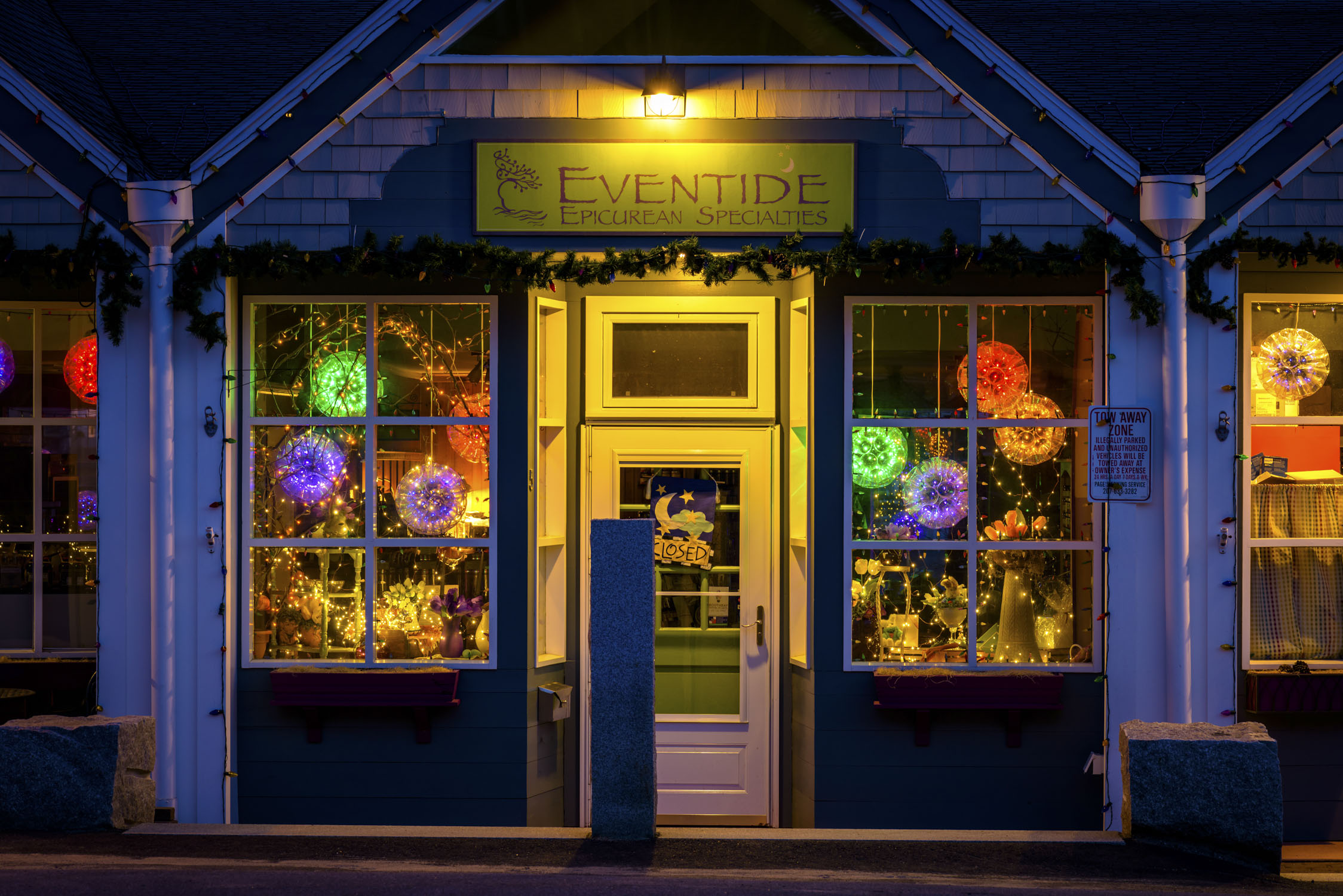 A storefront in the evening with many colorful lights inside