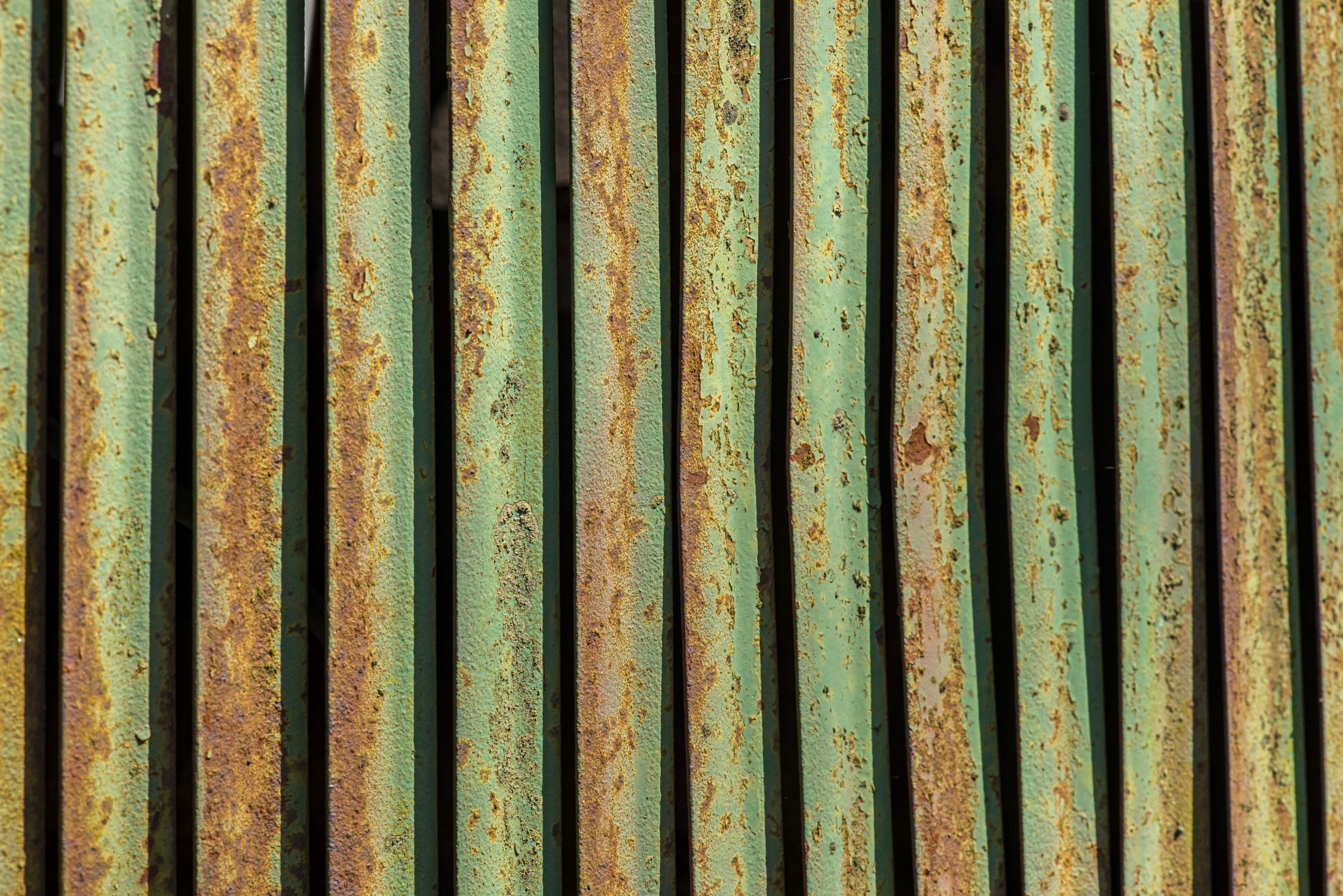 Slightly rusted green metal panels of an old car grill