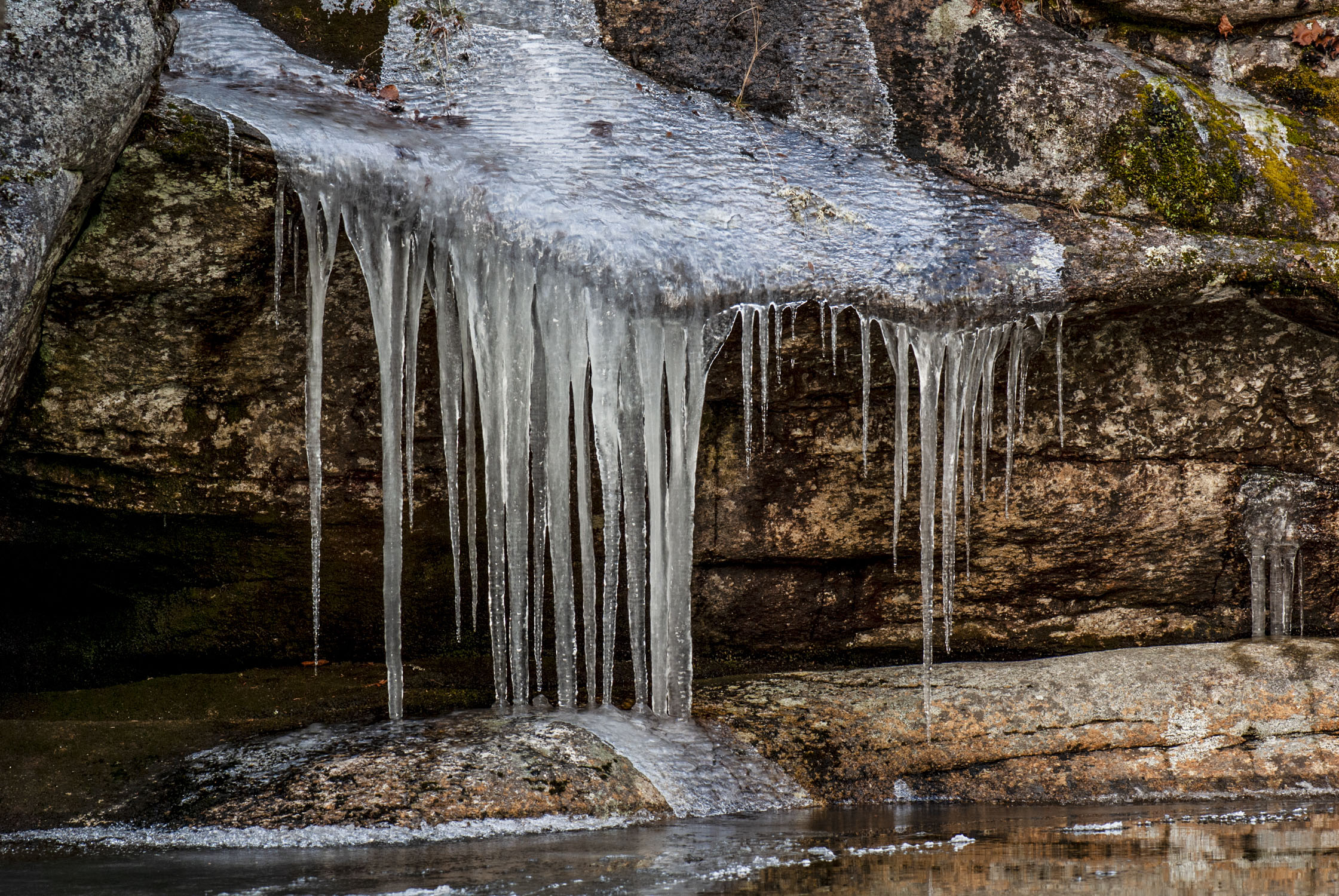 Water that has formed icicles on rock