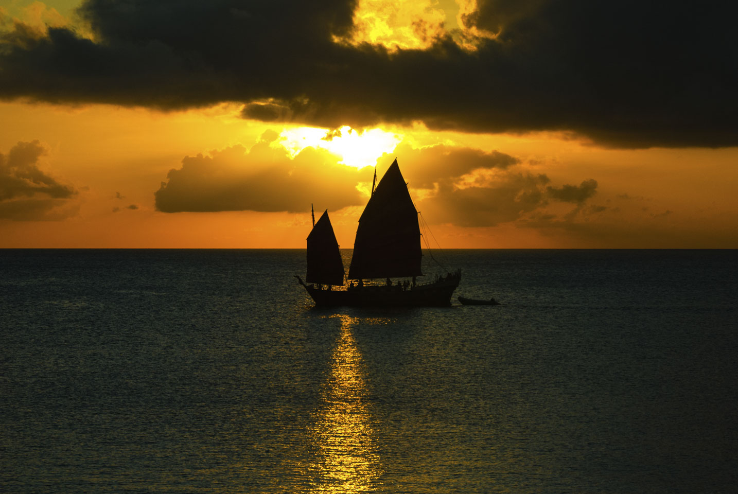 Pirate style ship in front of the setting sun