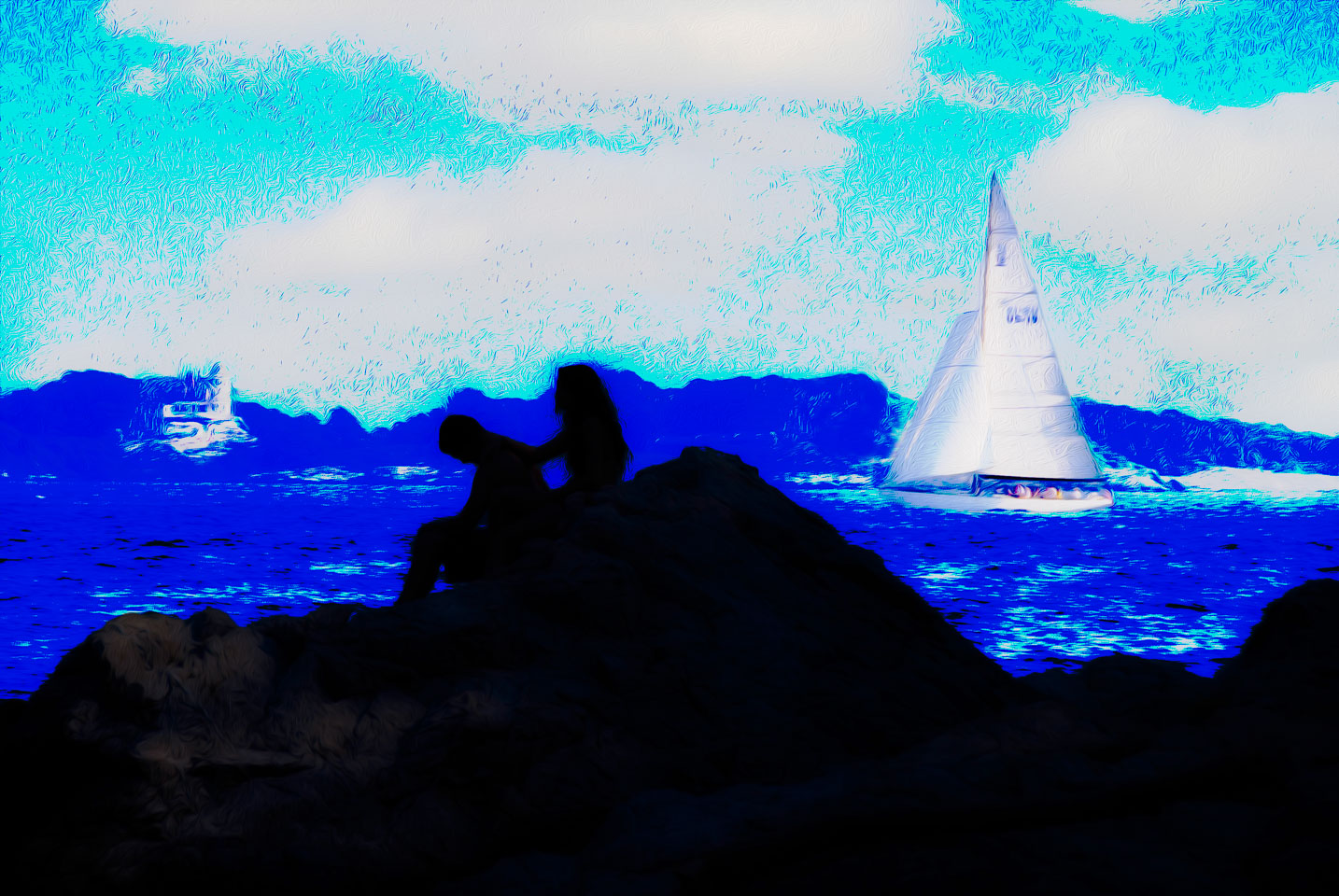 Silhouette of 2 people on rocks with a sailboat in the background