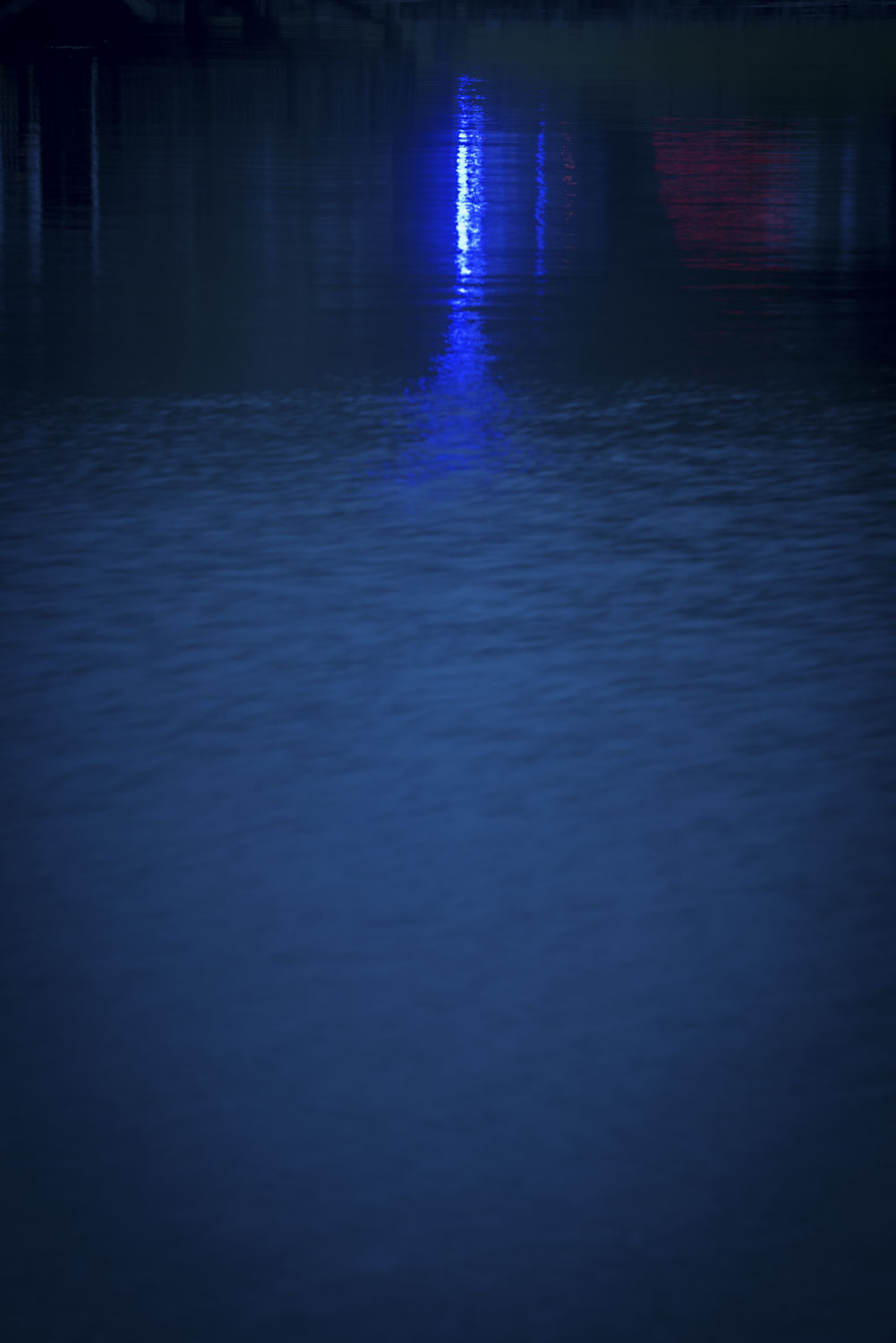 dark blue water with a blue light reflecting in it