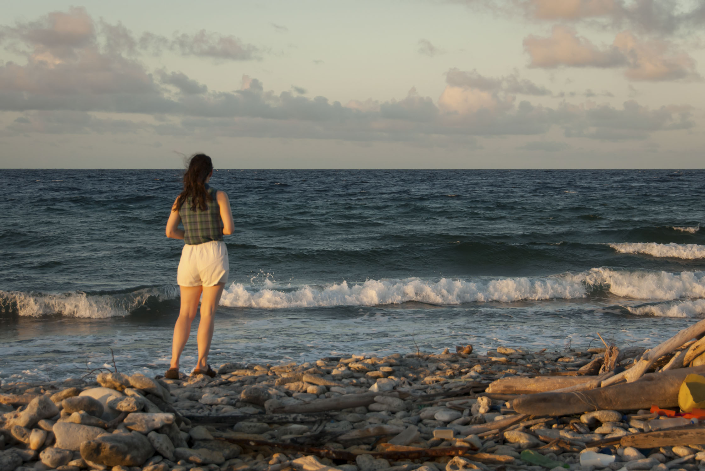 Woman along by the water, looking into the distance